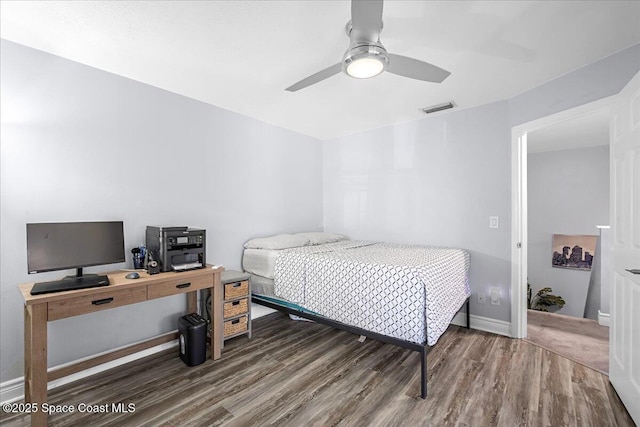 bedroom with baseboards, ceiling fan, visible vents, and wood finished floors