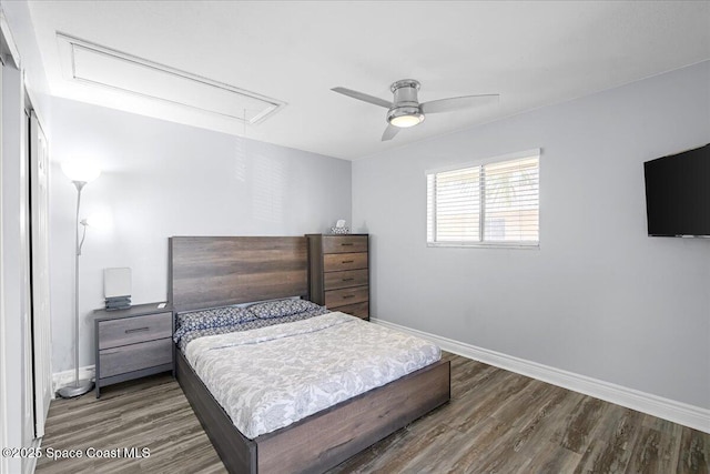 bedroom with a ceiling fan, wood finished floors, attic access, and baseboards