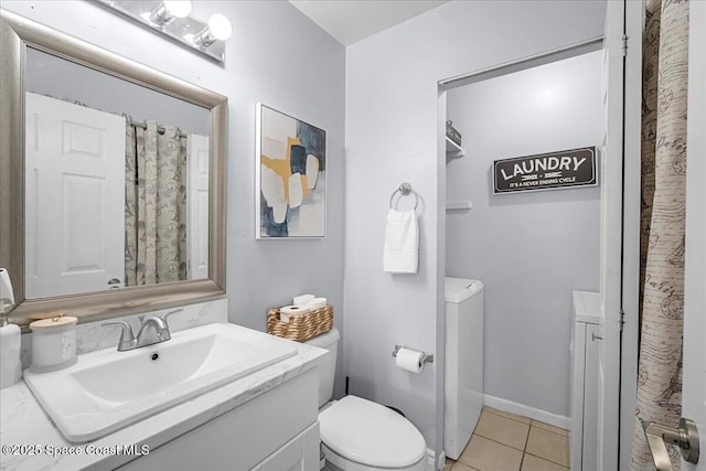 full bathroom featuring toilet, tile patterned flooring, vanity, washer and dryer, and baseboards