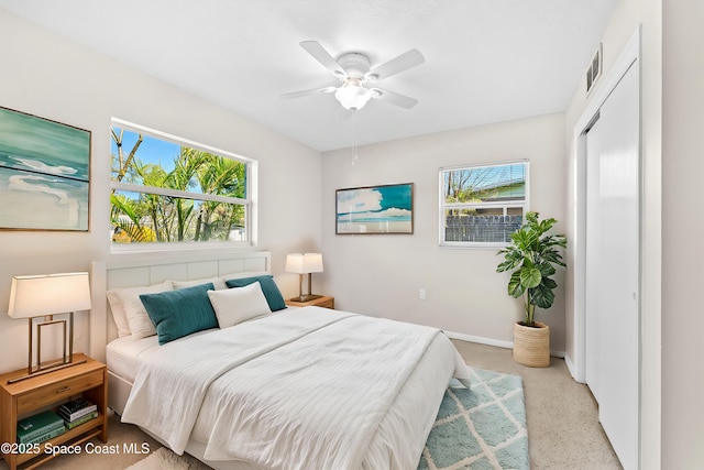 bedroom with a ceiling fan, multiple windows, visible vents, and baseboards