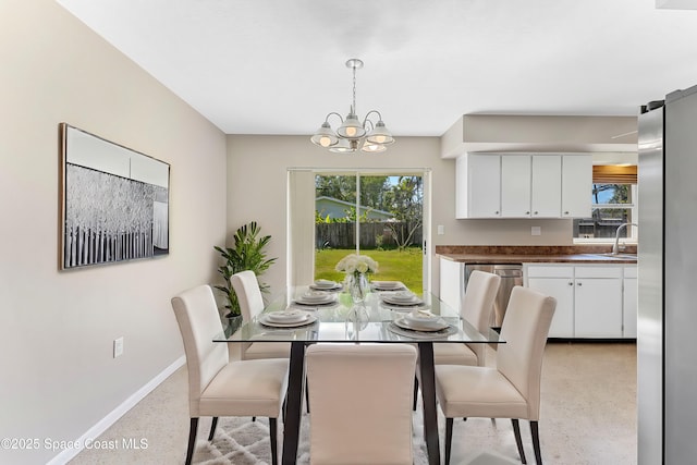 dining area with plenty of natural light, baseboards, light speckled floor, and a chandelier