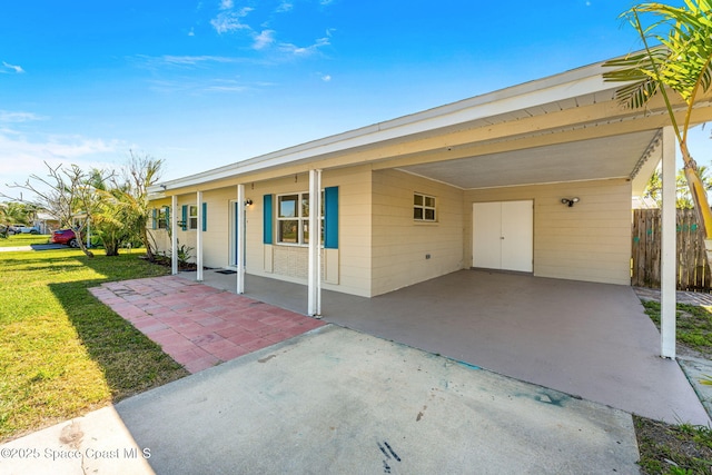 view of front of home with a front lawn, fence, and an attached carport