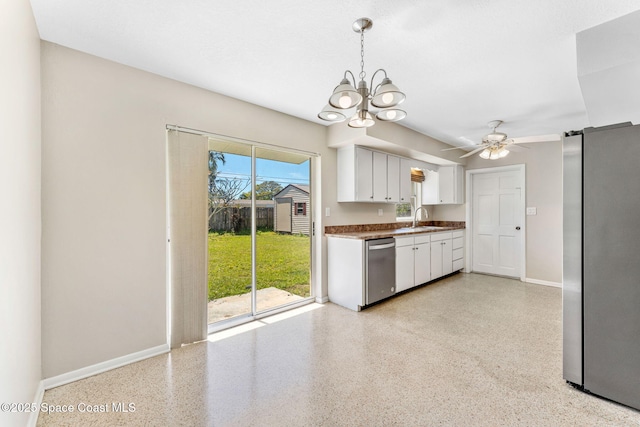 kitchen with light speckled floor, stainless steel appliances, baseboards, white cabinets, and dark countertops