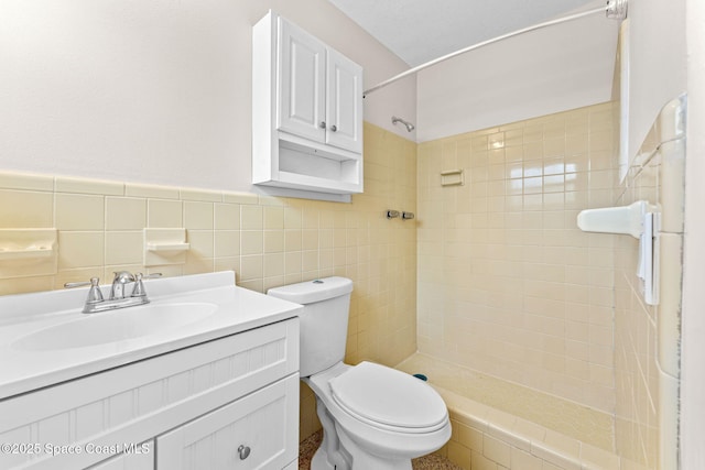 bathroom featuring a stall shower, tile walls, toilet, and vanity