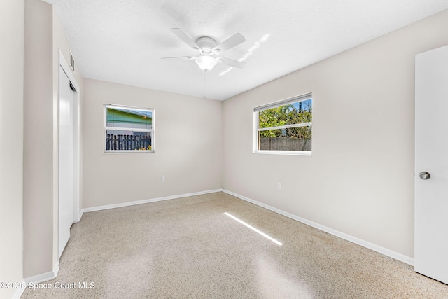 unfurnished bedroom featuring a closet, baseboards, a textured ceiling, and speckled floor