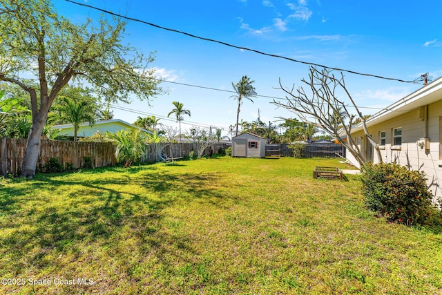 view of yard with an outbuilding, a storage unit, and a fenced backyard