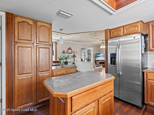 kitchen featuring visible vents, dark wood-type flooring, backsplash, stainless steel fridge, and tile counters