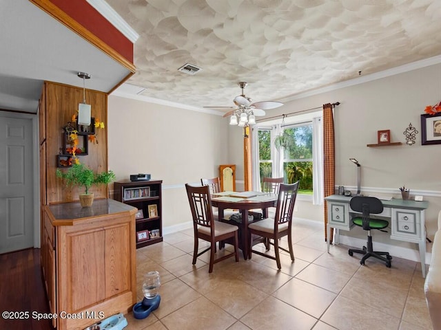 dining room with light tile patterned flooring, visible vents, baseboards, and ornamental molding