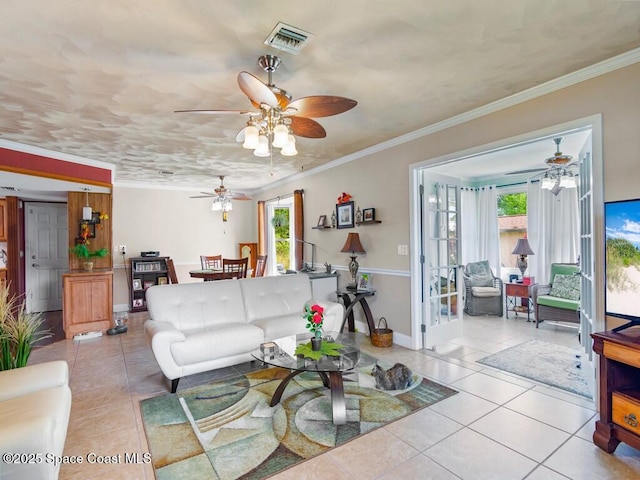 living area with light tile patterned flooring, visible vents, and crown molding