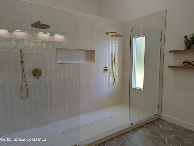 full bath featuring tile patterned floors, a walk in shower, and baseboards