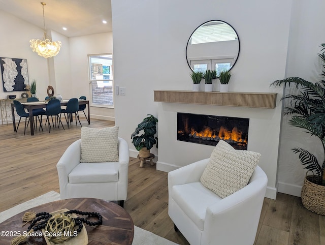 living room with recessed lighting, baseboards, a glass covered fireplace, and hardwood / wood-style flooring