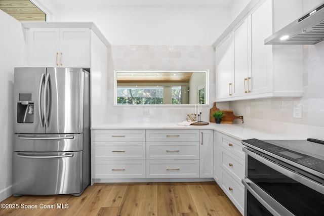 kitchen featuring stainless steel appliances, extractor fan, light countertops, white cabinetry, and tasteful backsplash