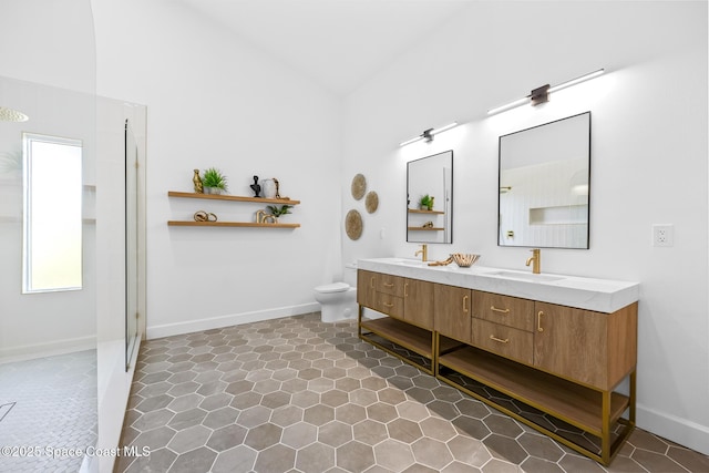 bathroom featuring vaulted ceiling, toilet, a walk in shower, and a sink