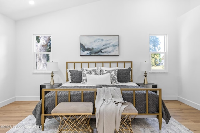 bedroom with lofted ceiling, recessed lighting, wood finished floors, and baseboards