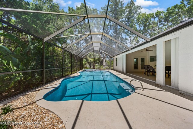outdoor pool with ceiling fan, french doors, a patio, and a lanai