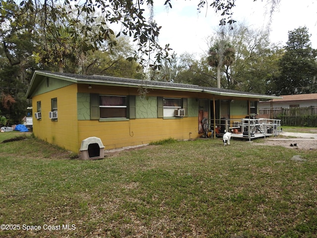 view of front of house with cooling unit, a front lawn, and fence