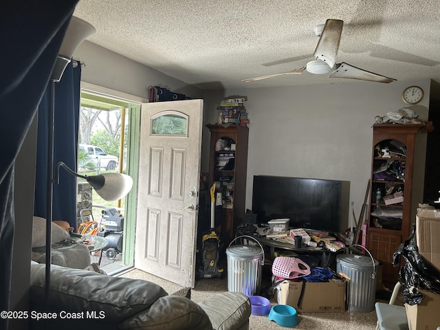 living room with a textured ceiling and ceiling fan