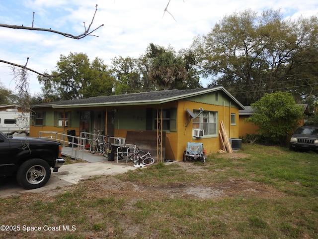 view of front facade featuring central AC and concrete block siding