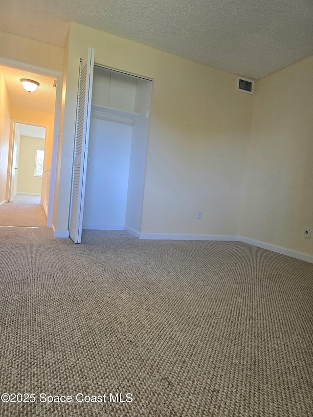 unfurnished bedroom featuring carpet, visible vents, and baseboards