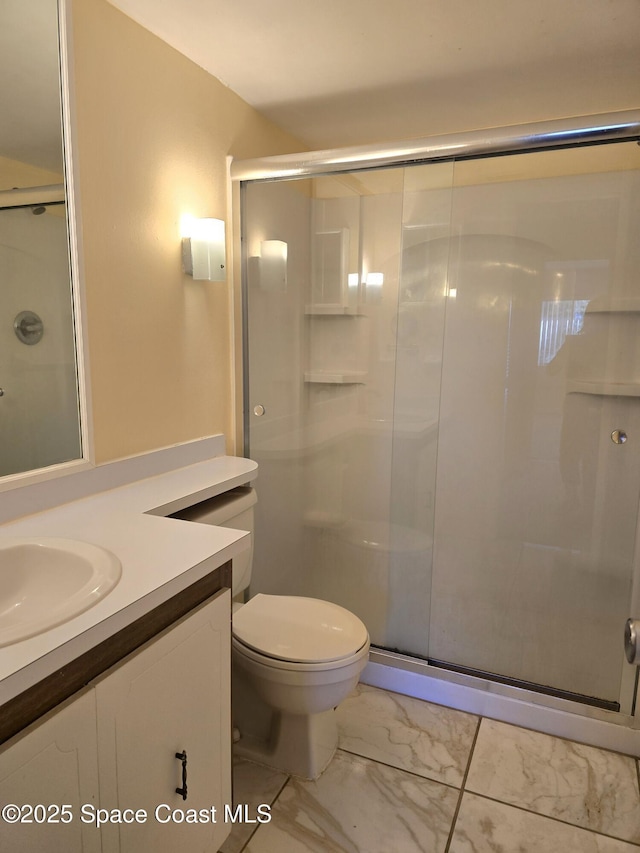 bathroom with marble finish floor, toilet, a shower stall, and vanity