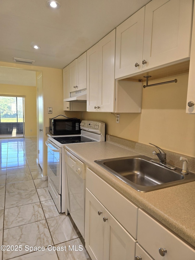 kitchen featuring white appliances, marble finish floor, under cabinet range hood, white cabinetry, and a sink