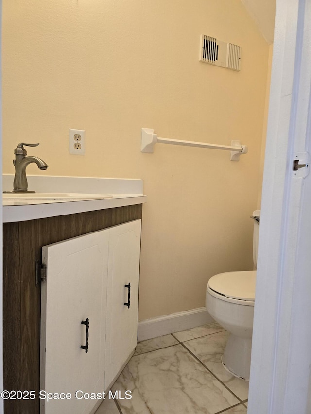 half bathroom with baseboards, visible vents, toilet, marble finish floor, and vanity