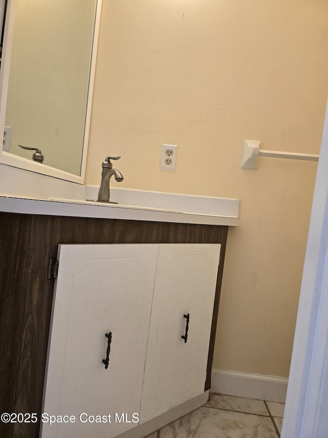 bathroom featuring marble finish floor and baseboards