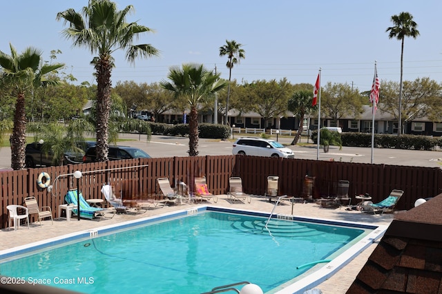 view of swimming pool featuring a patio and fence