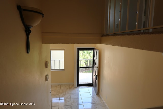 doorway to outside with marble finish floor and baseboards