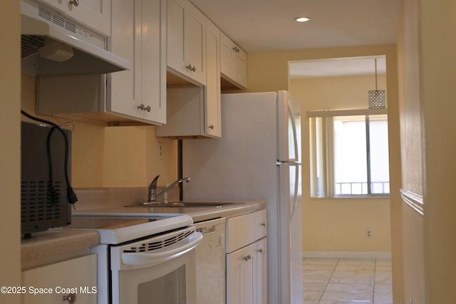 kitchen featuring dishwashing machine, white cabinets, a sink, under cabinet range hood, and baseboards