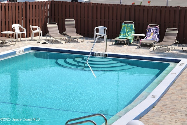 community pool featuring fence and a patio