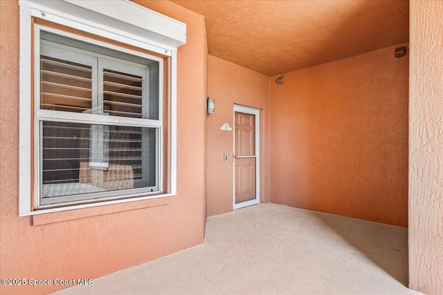 doorway to property featuring stucco siding