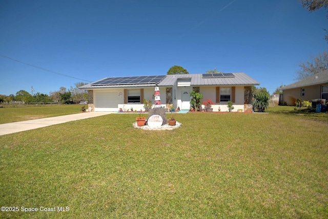 ranch-style home with a garage, concrete driveway, a front lawn, and solar panels