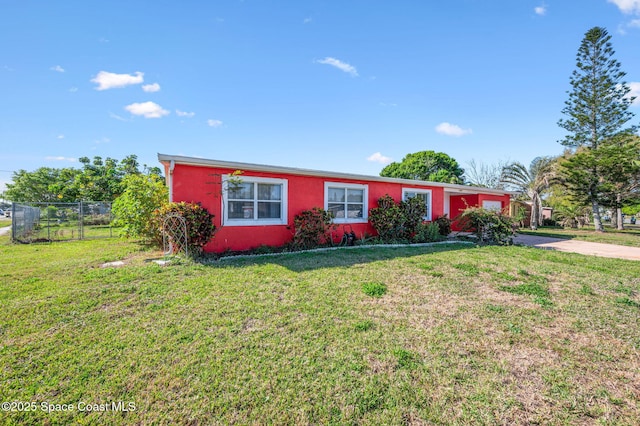 ranch-style home with concrete driveway, a front lawn, and fence