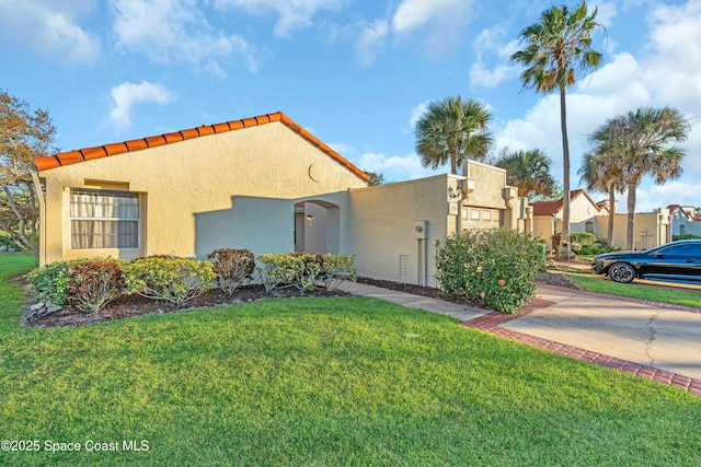 mediterranean / spanish home featuring a front lawn and stucco siding