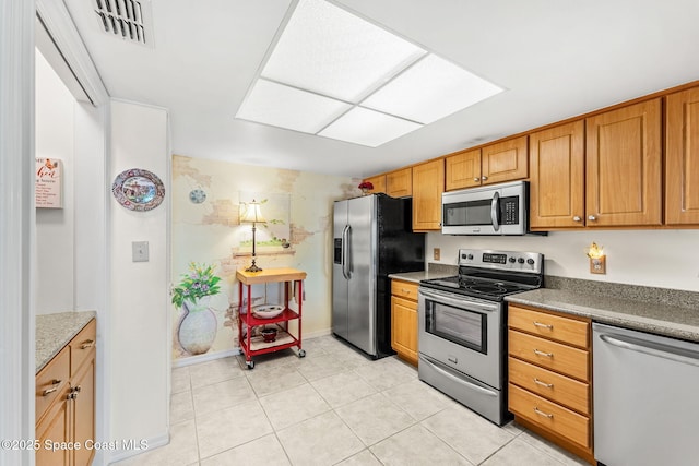 kitchen with light tile patterned floors, brown cabinetry, visible vents, and appliances with stainless steel finishes