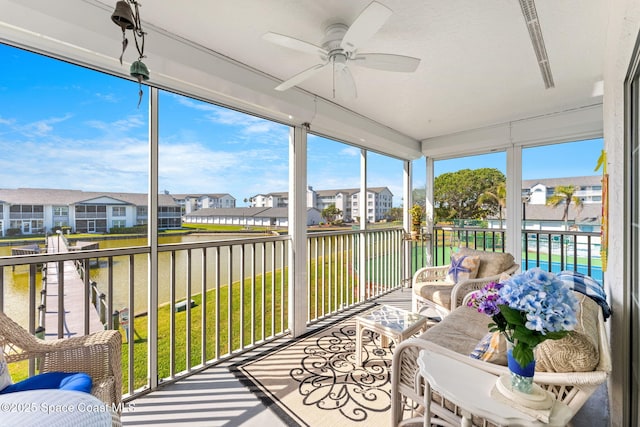 sunroom with a residential view, a healthy amount of sunlight, and ceiling fan