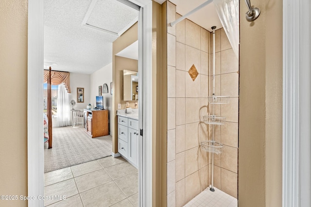 ensuite bathroom with tile patterned floors, a stall shower, a textured ceiling, connected bathroom, and vanity