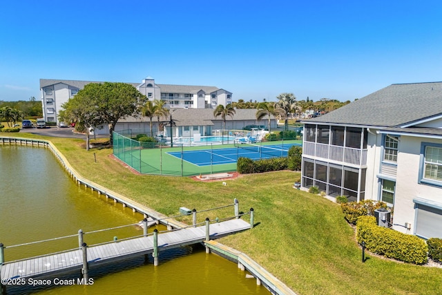 exterior space with a swimming pool, a water view, a yard, and fence