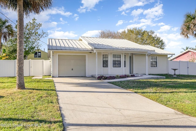 view of front of house with a front lawn, concrete driveway, fence, and an attached garage