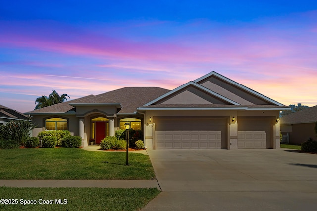 view of front of property with a garage, driveway, roof with shingles, a front lawn, and stucco siding