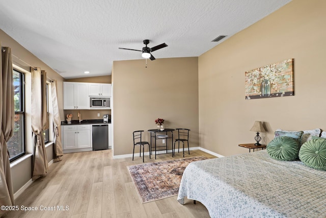 2033 Thistle Dr, Melbourne, FL 32935 - bedroom with a textured ceiling, visible vents, a sink, light wood finished floors, and lofted ceiling