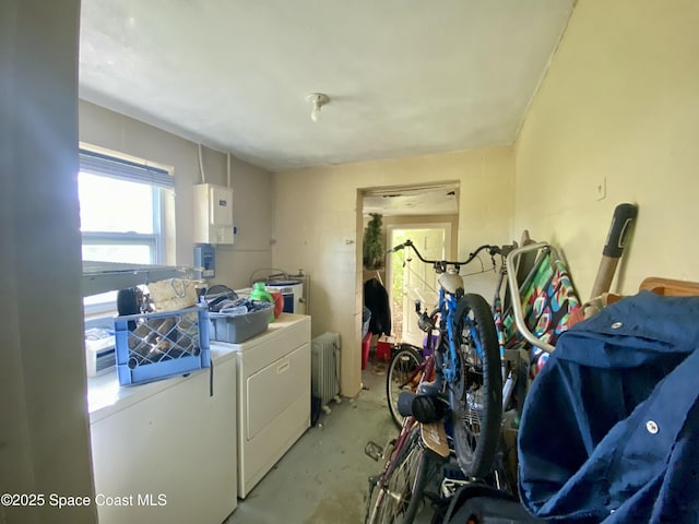 laundry area with laundry area, water heater, and washing machine and clothes dryer