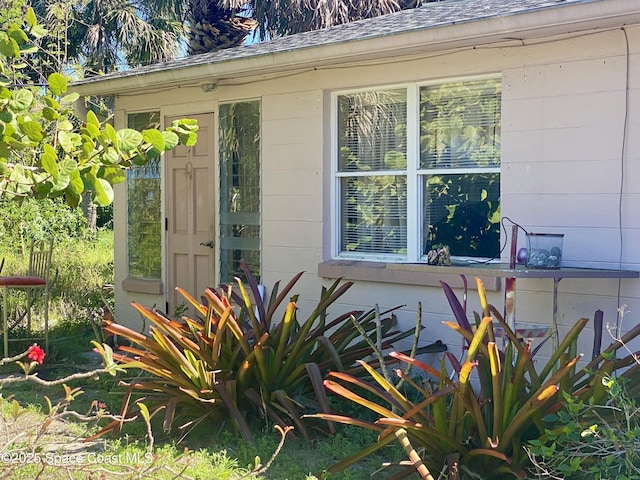 property entrance with roof with shingles