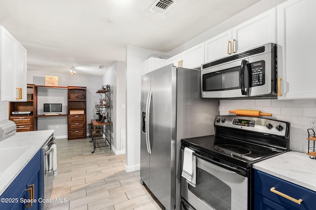 kitchen with stainless steel appliances, visible vents, decorative backsplash, and blue cabinetry