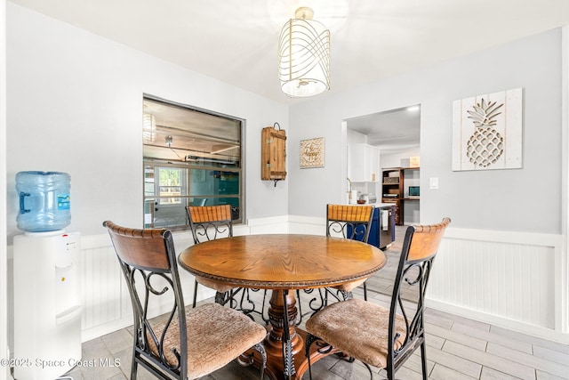 dining space with a wainscoted wall and light wood-type flooring