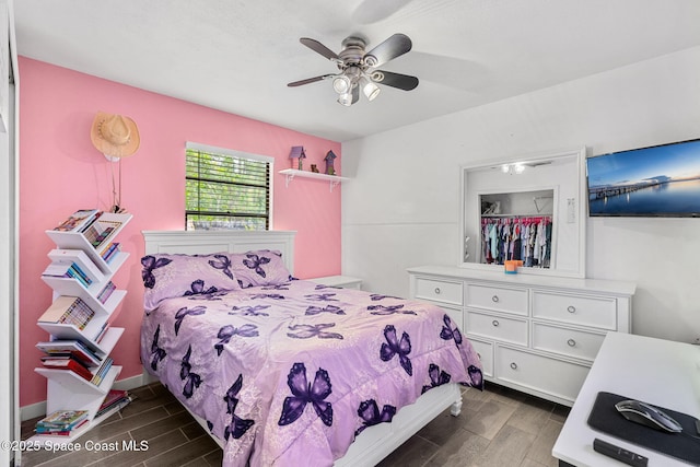 bedroom featuring a ceiling fan, wood finish floors, and baseboards