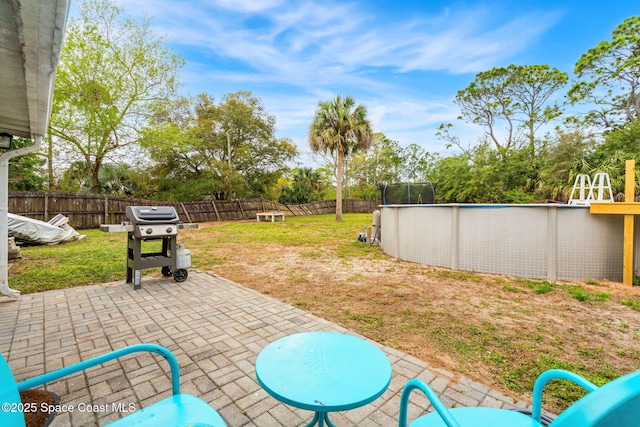 view of patio with a fenced in pool, a fenced backyard, and a grill