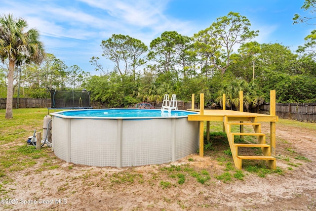 view of pool featuring a trampoline, fence, and a fenced in pool