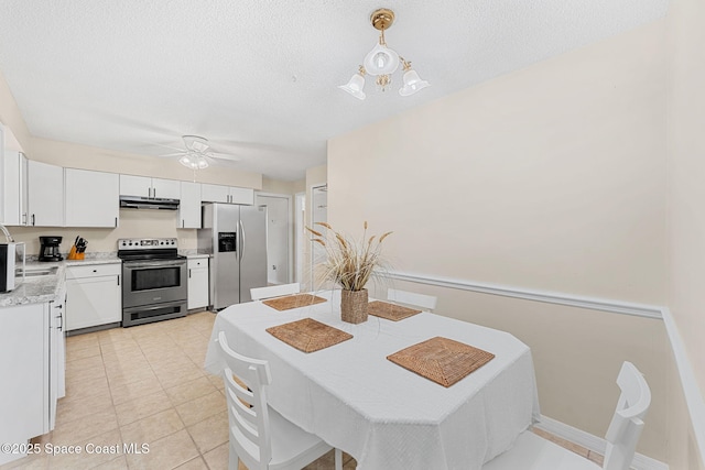 dining area with light tile patterned floors, baseboards, ceiling fan, and a textured ceiling
